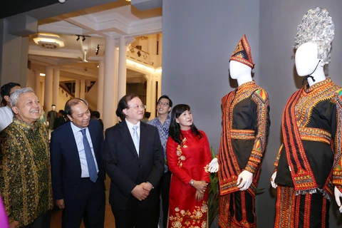 Thứ trưởng Tạ Quang Đông và các đại biểu tham quan triển lãm. (Ảnh: Hoàng Hiếu/TTXVN)