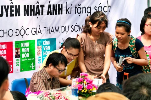 Nhà văn Nguyễn Nhật Ánh ký tặng độc giả tại Hà Nội. Có rất nhiều gia đình có bố mẹ và các con cùng là fan của bộ truyện. (Ảnh: Kim Đồng)
