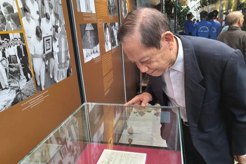 Ông Dương Tự Minh nhìn lại những trang báo Nhựa sống đang trưng bày tại Di tích Nhà tù Hỏa Lò. (Ảnh: Minh Thu/Vietnam+)