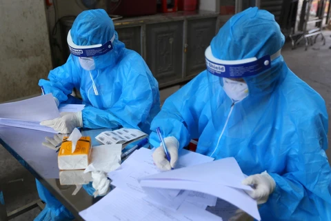 Nhân viên y tế lấy thông tin tất cả người dân lấy mẫu xét nghiệm tại Đan Phượng, Hà Nội. (Ảnh: Hoàng Hiếu/TTXVN)