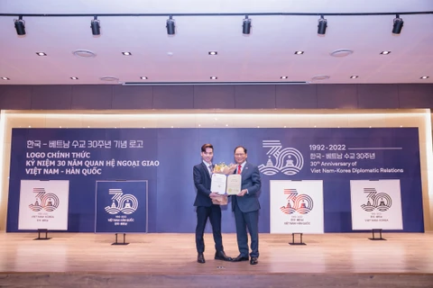 Đại sứ Hàn Quốc Park Noh-wan (phải) trao giải cho Ngô Quang Trung, người đạt giải Cuộc thi thiết kế logo kỷ niệm 30 năm quan hệ ngoại giao Việt Nam-Hàn Quốc. (Ảnh: PV/Vietnam+)