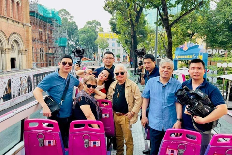 Nhà báo Trần Mai Hưởng và nhà báo Giản Thanh Sơn cùng ekip trên xe bus hai tầng. (Ảnh: VNEWS)