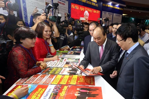 Thủ tướng Nguyễn Xuân Phúc thăm gian trưng bày của Thông tấn xã Việt Nam tại Hội báo toàn quốc 2019. (Ảnh: Huy Hùng/TTXVN)