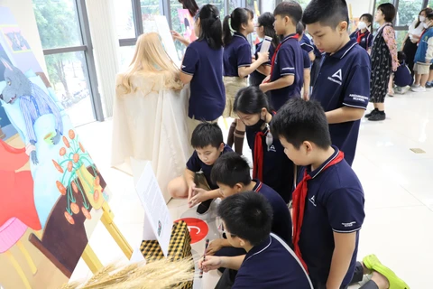 Các em học sinh thích thú khám phá không gian cổ tích trong triển lãm. (Ảnh: PV/Vietnam+)