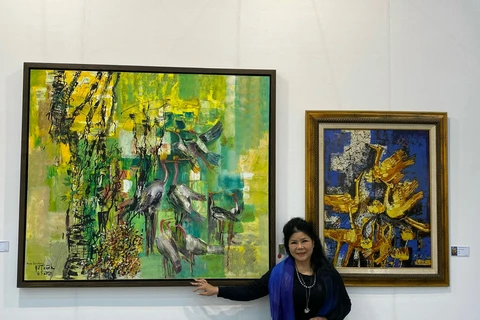 Họa sỹ Văn Dương Thành bên các tác phẩm của mình trong Triển lãm Nghệ thuật Quốc tế Daejeon. (Ảnh: PV/Vietnam+) 