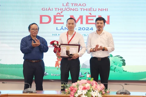 Đại diện Nhà xuất bản Trẻ thay mặt tác giả Lý Lan nhận giải Hiệp sỹ Dế mèn. (Ảnh: PV/Vietnam+)