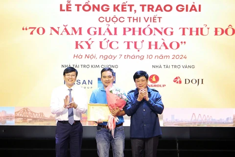 Ông Nguyễn Thế Kỷ, Chủ tịch Hội đồng Lý luận, phê bình văn học nghệ thuật Việt Nam (bìa phải) cùng ông Hồ Quang Lợi, Phó Chủ tịch Hội Truyền thông số Việt Nam trao giải Nhất cho tác giả Đan Nhiễm. (Ảnh: PV/Vietnam+)