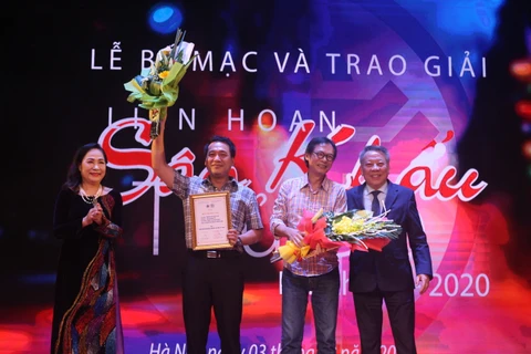 Phó giám đốc Nhà hát Kịch Việt Nam ông Kiều Minh Hiếu và đạo diễn Trần Lực nhận giải vàng cho 'Người tốt nhà số 5' và 'Bạch đàn liễu.' (Ảnh: Minh Anh/Vietnam+)
