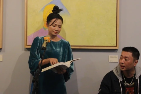 Ca sỹ Giang Trang đọc ''Bến lạ'' tại khai mạc triển lãm ''Về bến lạ'' của Lê Thiết Cương. (Ảnh: Minh Anh/Vietnam+)