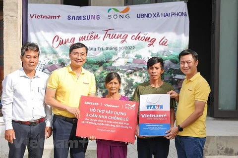 Hai mẹ con anh Nguyễn Minh Hùng tại thôn Văn Trị nhận hộ trợ từ Báo VietnamPlus và Samsung. (Ảnh: Minh Sơn/Vietnam+)