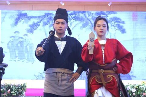 Hai trang phục phỏng dựng thời Trần có sử dụng phụ kiện như kiếm và lệnh bài. (Ảnh: Minh Anh/Vietnam+)