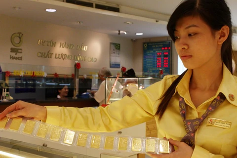 Nhân viên đang kiểm tra chất lượng vàng miếng trước khi giao dịch (Ảnh: TTXVN)