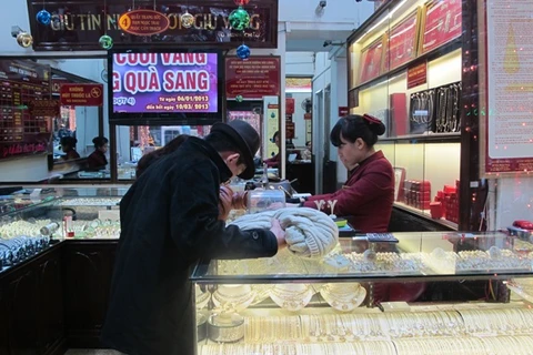Khách hàng đến giao dịch vàng miếng tại hệ thống Bảo Tín Minh Châu (Ảnh: Đức Duy/Vietnam+)