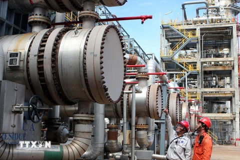 Các kỹ sư nhà máy Lọc dầu Dung Quất đang kiểm tra việc vận hành trang thiết bị (Ảnh: TTXVN)