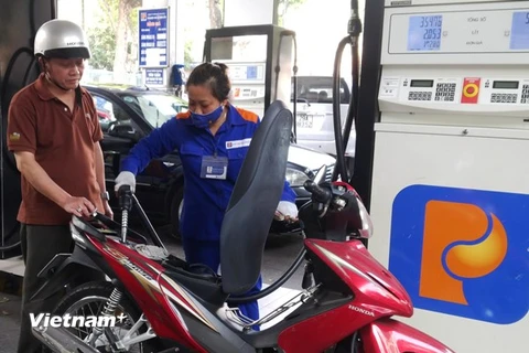 Nhân viên Petrolimexn đang bán xăng cho khách hàng (Ảnh: Đức Duy/Vietnam+)