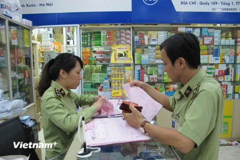Lực lượng quản lý thị trường Hà Nội đang kiểm tra các cơ sở kinh doanh tân dược tại Trung tâm thuốc Hapu (Ảnh: Đức Duy/Vietnam+)