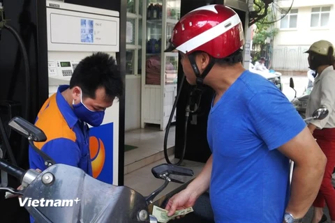 Nhân viên Petrolimex đang bán xăng cho khách hàng (Ảnh: Đức Duy/Vietnam+)