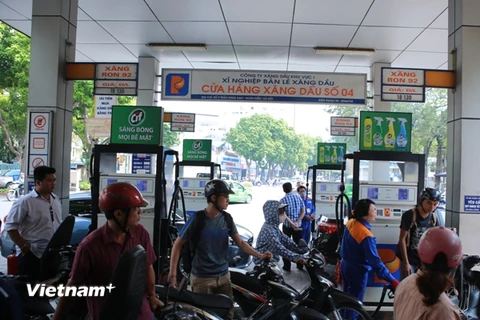 Nhân viên Petrolimex đang bán xăng cho khách hàng (Ảnh: PV/Vietnam+)