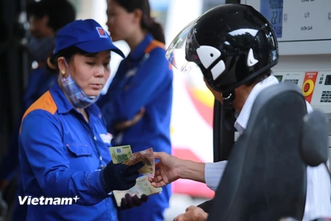 Nhân viên Petrolimex đang bán xăng cho khách hàng (Ảnh: Minh Sơn/Vietnam+)