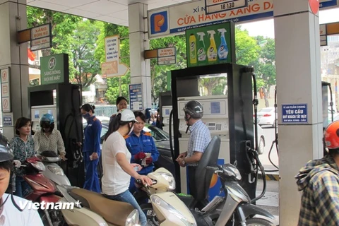 Nhân viên Petrolimex đang bán xăng cho khách hàng (Ảnh: Đức Duy/|Vietnam+)