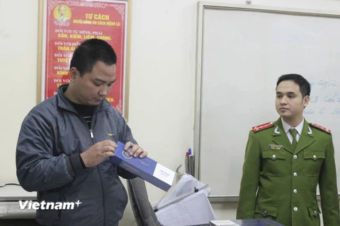 Lực lượng chức năng kiểm tra số thuốc lá điếu nhập lậu vừa thu giữ (Ảnh: Đức Duy/Vietnam+)
