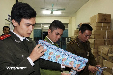 Đoàn liên ngành thành phố Hà Nội đang kiểm đếm số bánh kẹo và ômai nhập lậu (Ảnh: Đức Duy/Vietnam+)
