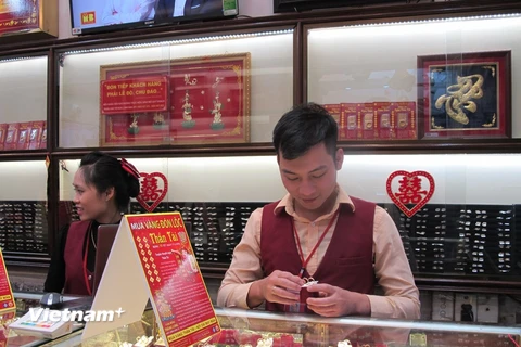 Nhân viên kinh doanh của Công ty Bảo Tín Minh Châu đang kiểm tra vàng miếng (Ảnh: Đức Duy/Vietnam+