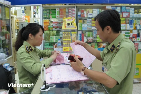 Lực lượng Quản lý thị trường Hà Nội đang kiểm tra các cơ sở kinh doanh thuốc tân dược. (Ảnh: Đức Duy/Vietnam+)