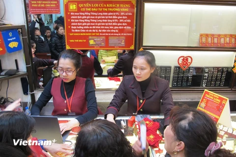 Nhân viên Công ty Bảo Tín Minh Châu đang giao dịch với khách hàng. (Ảnh: Đức Duy/Vietnam+)