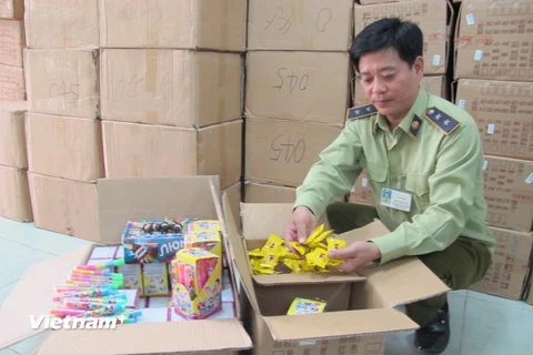 Cán bộ Đội Quản lý thị trường số 15 đang kiểm tra lô bánh kẹo nhập lậu từ Trung Quốc. (Ảnh: Đức Duy/Vietnam+)