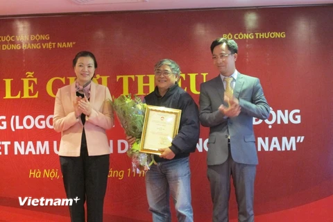 Đại diện Ban chỉ đạo trao chứng nhận cho họa sỹ Nguyễn Văn Thân, người sáng tác logo chính thức cuộc vận động "Người Việt Nam ưu tiên dùng hàng Việt Nam. (Ảnh: Đức Duy/Vietnam+)