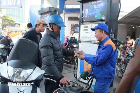 Nhân viên Petrolimex đang bán xăng cho khách hàng. (Ảnh: Đức Duy/Vietnam+)