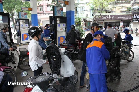 Nhân viên Petrolimex đang bán xăng cho khách hàng. (Ảnh: Đức Duy/Vietnam+)