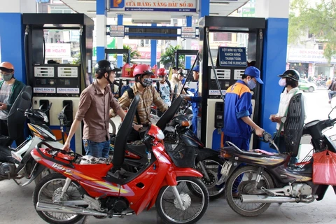 Nhân viên Petrolimex đang bán xăng cho khách hàng. (Ảnh: Đức Duy/Vietnam+)