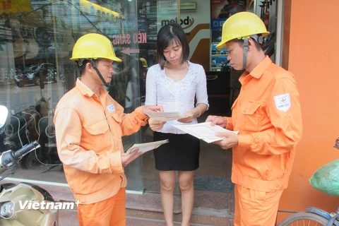 Nhân viên EVN Hà Nội tuyên truyền sử dụng điện an toàn, tiết kiệm. (Ảnh: Đức Duy/Vietnam+)