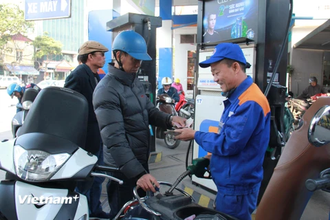 Nhân viên Petrolimex đang bán xăng cho khách hàng. (Ảnh: Đức Duy/Vietnam+)