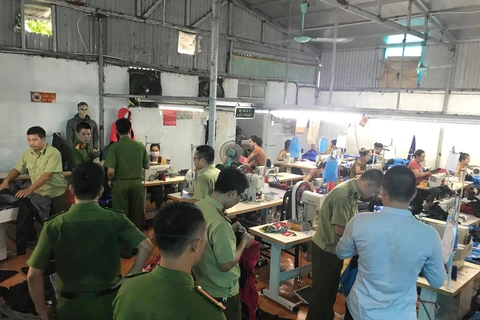 Lực lượng liên ngành kiểm tra một cơ sở sản xuất túi xách trên địa bàn Hà Nội. (Ảnh: PV/Vietnam+)