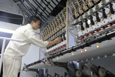 Công nhân tại Nhà máy sản xuất xơ sợi polyester. (Ảnh: PV/Vietnam+)