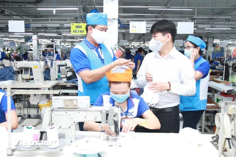 Sản xuất khẩu trang sử dụng vải dệt kim kháng khuẩn tại một đơn vị thành viên của Vinatex. (Ảnh: PV/Vietnam+)