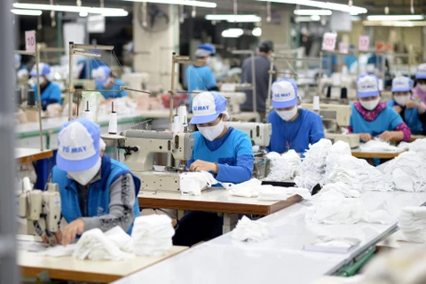 Sản xuất khẩu trang vải kháng khuẩn tại Dệt Kim Đông Xuân. (Ảnh: Đức Duy/Vietnam+)