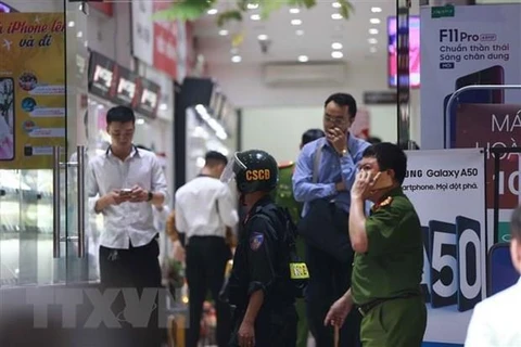 Cảnh sát kiểm tra, khám xét tại cửa hàng điện thoại Nhật Cường mobile ở 33 Lý Quốc Sư, Hà Nội. (Ảnh: Doãn Tấn/TTXVN)
