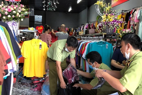 Lực lượng Quản lý thị trường tỉnh Lạng Sơn kiểm tra hàng hóa có dấu hiệu giả mạo nhãn hiệu tại một cửa hàng trên địa bàn. (Ảnh: Vietnam+)