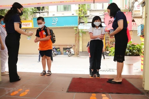 Học sinh được hướng dẫn các biện pháp phòng, chống dịch bệnh khi đến lớp. (Ảnh: TTXVN)