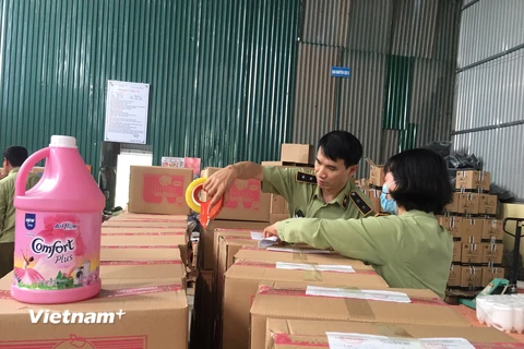 Lực lượng Quản lý thị trường Hà Nội kiểm tra kho hàng sản xuất nước giặt giả nhãn hiệu nổi tiếng. (Ảnh: PV/Vietnam+)
