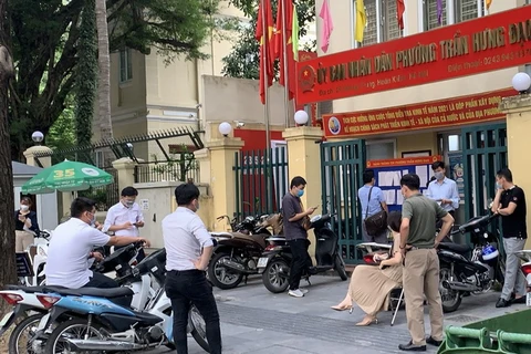 Người dân chờ lấy Giấy đi đường tại phường Trần Hưng Đạo lúc 17 giờ ngày 9/8 (Ảnh: Tùng Lâm/Vietnam+)