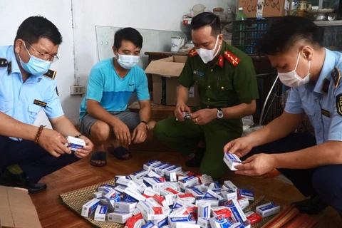 Lực lượng chức năng tạm giữ hàng trăm hộp thuốc điều trị COVID-19 không rõ chất lượng trên địa bàn Hà Nội. (Ảnh: PV/Vietnam+)