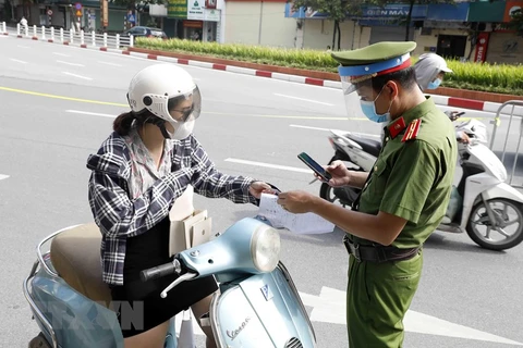 Lực lượng chức năng kiểm tra các phương tiện lưu thông trong thời gian giãn cách xã hội. (Ảnh: TTXVN)