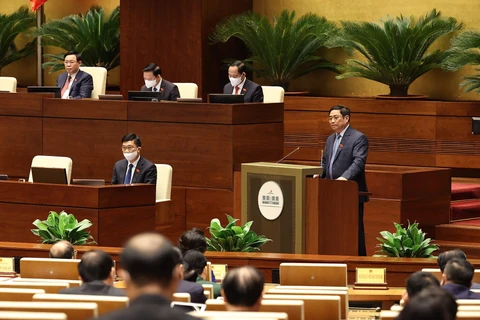 Thủ tướng Phạm Minh Chính trình bày Báo cáo kết quả thực hiện kế hoạch phát triển kinh tế-xã hội năm 2021; dự kiến kế hoạch phát triển kinh tế-xã hội năm 2022. (Ảnh: TTXVN)