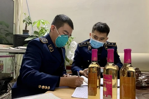 Lực lượng Quản lý thị trường Hà Nội đang kiểm tra sản phẩm nước giải khát dấm táo. (Ảnh: PV/Vietnam+)