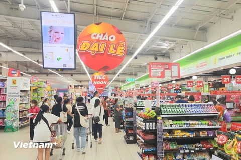 Người tiêu dùng mua sắm hàng hóa tại siêu thị. (Ảnh: PV/Vietnam+)